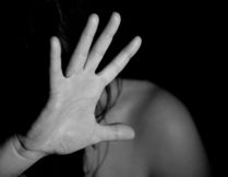 zdjęcie przedstawiające osobę zasłaniającą się otwartą dłonią przed uderzeniem