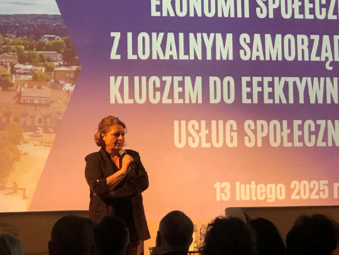 Na zdjęciu kobieta - dyrektor Centrum Usług Społecznych przemawiająca na konferencji.